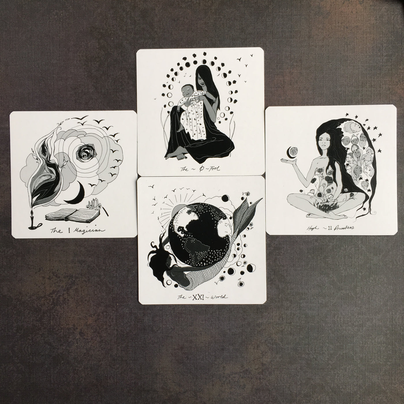 The Fool, the Magician, High Priestess and the World cards from the Dark Days Tarot, a square black & white indie deck. 