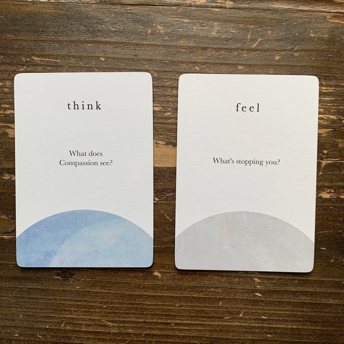 close-up of cards from the compass cards deck asking What does compassion see? and What's stopping you?